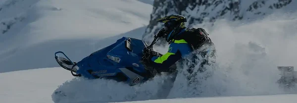 A banner image of a man riding a snowmobile.